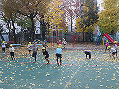 落ち葉で遊ぶ子供たちの写真